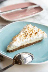 a piece of pie on a blue plate with a spoon at INNSiDE by Meliá Zaragoza in Zaragoza