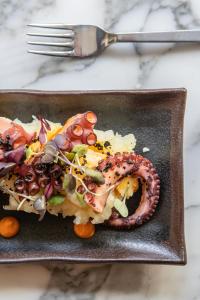a plate of food with a pretzel and vegetables at INNSiDE by Meliá Zaragoza in Zaragoza