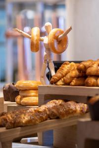 a person holding a donut and a bunch of pastries at INNSiDE by Meliá Zaragoza in Zaragoza