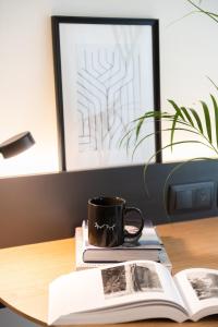 a coffee cup sitting on top of a book on a desk at INNSiDE by Meliá Zaragoza in Zaragoza