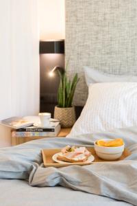 a tray with a plate of food on a bed at INNSiDE by Meliá Zaragoza in Zaragoza