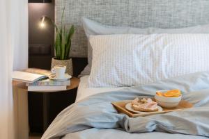 a tray with a plate of food on a bed at INNSiDE by Meliá Zaragoza in Zaragoza