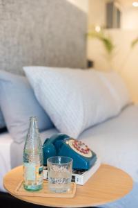 a table with a bottle and a remote control and a glass at INNSiDE by Meliá Zaragoza in Zaragoza