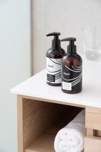 two bottles of soap sitting on a shelf in a bathroom at INNSiDE by Meliá Zaragoza in Zaragoza