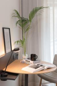 a desk with a potted plant and a book at INNSiDE by Meliá Zaragoza in Zaragoza