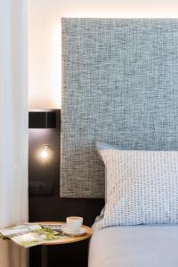 a bed with a table with a coffee cup on it at INNSiDE by Meliá Zaragoza in Zaragoza