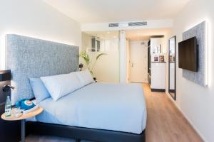 a bedroom with a blue bed and a table at INNSiDE by Meliá Zaragoza in Zaragoza