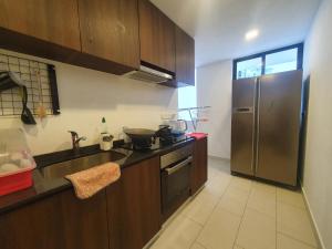 a kitchen with a stainless steel refrigerator and a sink at Landmark by Katana 3BR Romantic Luxury Seaview Homestay Gurney无敌海景三房套房 in Tanjong Tokong