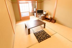 a living room with a coffee table and a window at Business Hotel Kawakami in Kumano