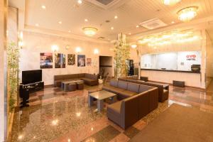 a lobby with couches and a tv in a building at Business Hotel Kawakami in Kumano