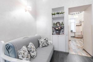 ein Wohnzimmer mit einer grauen Couch mit Kissen in der Unterkunft Dominicana l Apartments l Lviv Historical City Center in Lwiw