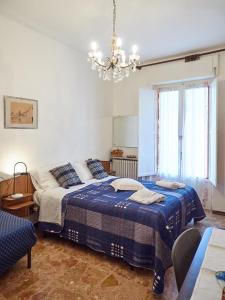 una camera con due letti e un lampadario a braccio di Appartamento Ghisallo a Magreglio