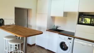 a kitchen with a washing machine and a wooden counter top at Chambres La Prévôté - Randonneurs et Pèlerins - Ancien couvent contre la Cathédrale in Le Puy-en-Velay