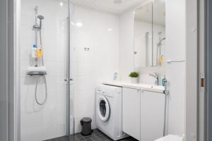 a white bathroom with a washing machine and a shower at Hiisi Homes Vantaa Kaivoksela in Vantaa +46 photos