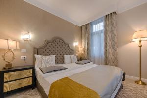 a bedroom with a large bed and a large window at Hotel Versay in Băile Herculane