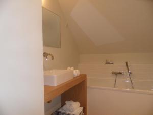 ein Badezimmer mit einem Waschbecken und einer Badewanne in der Unterkunft B&B Korsele 59 in Horebeke