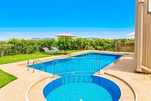 una piscina en un patio con sombrilla en Villa Panagiotis Chania, en Daratso