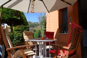 a table and chairs on a patio with an umbrella at AnnaDes Apartments & Studios Chios in Karfas