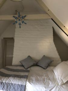 a white bed with two pillows in a room at Bluebell Cottage in Kilmore Quay