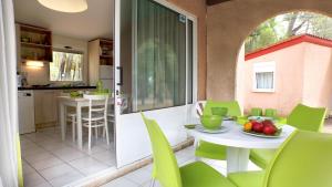 une cuisine et une salle à manger avec une table et des chaises dans l'établissement VVF Montagnac Hérault, à Montagnac