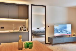 a living room with a television and a bedroom at Warth52-W52 Apartments in Warth am Arlberg