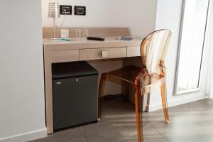 a wooden desk with a chair next to a window at Hotel Adlon in Lido di Jesolo