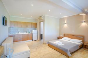 Kapsogeorgis Rooms في كوينيرا: غرفة نوم كبيرة مع سرير ومطبخ