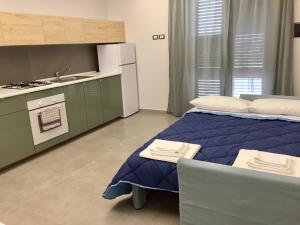Cet appartement comprend une chambre avec un lit bleu et une cuisine. dans l'établissement Orchidea dell'Etna, à Zafferana Etnea