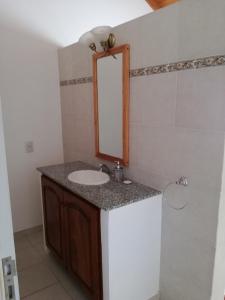 een badkamer met een wastafel en een spiegel bij White Field Houses and Spa in Villa Las Rosas