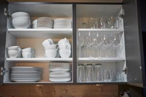 um armário cheio de pratos, copos e pratos em Appartements Der Fuchsbau em Saalbach-Hinterglemm