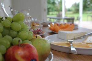 a table topped with plates of food with apples and cheese at B&B Korsele 59 in Horebeke