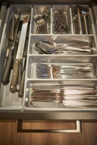 a drawer filled with plates and silver utensils at Appartements Der Fuchsbau in Saalbach-Hinterglemm