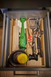 un cajón lleno de utensilios de cocina y un contenedor verde en Appartements Der Fuchsbau, en Saalbach Hinterglemm