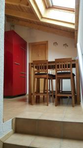uma cozinha com uma mesa e duas cadeiras e um armário vermelho em Les Combles des Murailles em Champéry