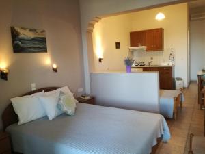 a bedroom with a white bed and a kitchen at Maria Studios in Patitiri