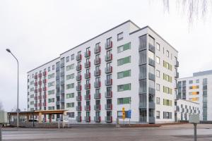 a white building with colorful windows on a street at Hiisi Homes Vantaa Kaivoksela in Vantaa