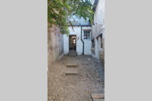 
a narrow alleyway leads to a stone building at The Merchant's House in Penryn
