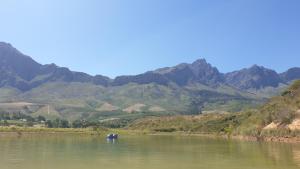 an elephant in the water with mountains in the background at Mont Rouge Cottage in Tulbagh