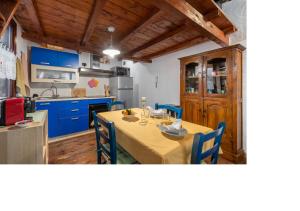 uma cozinha com uma mesa e armários azuis num quarto em Oldtown romantic apartment em Cagliari