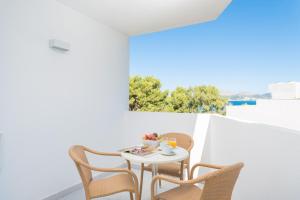 a small white table and chairs on a balcony at Aparthotel Ses Fotges in Playa de Muro