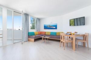 a living room with a couch and a table at Aparthotel Ses Fotges in Playa de Muro