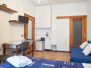 een kamer met een bed, een tafel en een keuken bij Appartamento Ghisallo in Magreglio