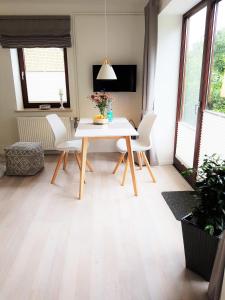 a dining room with a white table and chairs at Ferienwohnungen am Danewerk in Dannewerk