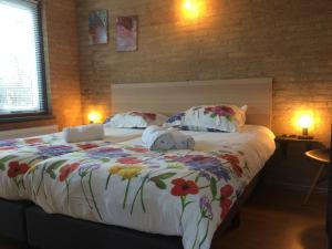 ノールトウェイケルハウトにあるBungalow 221のベッドルーム1室(花の咲く大型ベッド1台付)