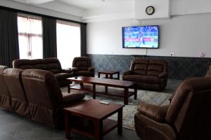 a waiting room with couches and a flat screen tv at Lodge @ Leadwood in Boksburg