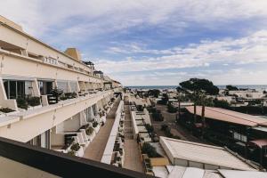 uma vista a partir da varanda de um edifício com mesas e cadeiras em VILLAGE NATURISTE em Cap d'Agde