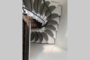 eine Wendeltreppe in einem Zimmer mit einer weißen Wand in der Unterkunft Ferienwohnung Haus Ruhrgebiet in Mülheim an der Ruhr