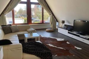 a living room with a couch and a flat screen tv at Ferienwohnung Haus Ruhrgebiet in Mülheim an der Ruhr