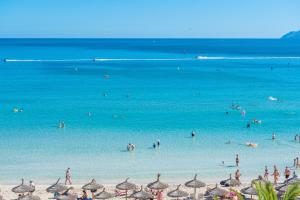 a group of people in the water at a beach at Aparthotel Ses Fotges in Playa de Muro