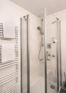 a shower with a glass door in a bathroom at Hotel Fischerwirt in Ismaning